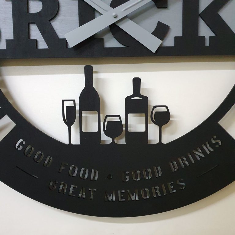 Clienții noștri și-au imaginat ceasul cu ChatGPT. Noi l-am transformat în realitate Detaliu ceas Bricks — zona inferioară cu siluete sticle vin și pahare decupate laser, text Good Food Good Drinks Great Memories